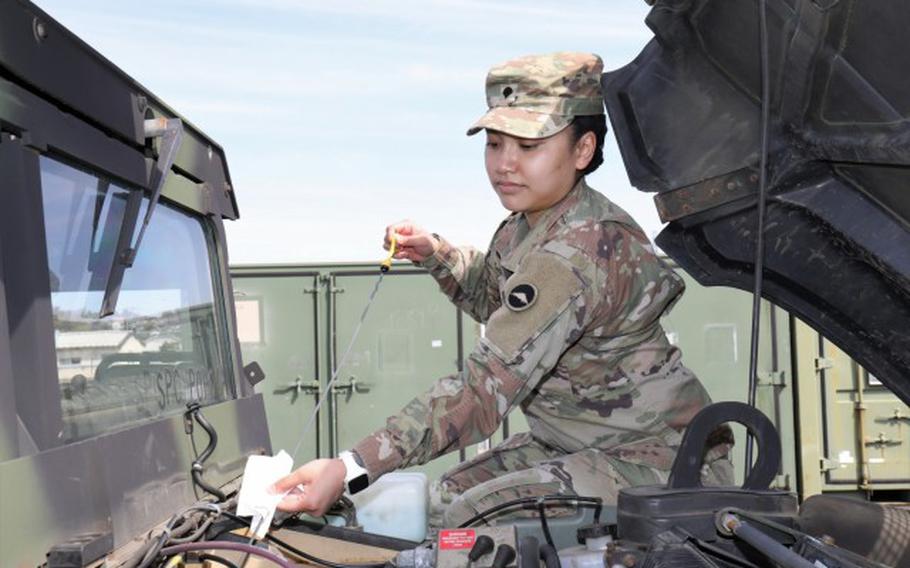 Spc. AnnaMarie Popoca, a transportation management coordinator assigned to 623rd Movement Control Team, 35th Combat Sustainment Support Battalion, checks the oil of her Humvee during routine maintenance at Sagami General Depot, Japan, March 7, 2022. Popoca, 22, chose to join the Army and follow in the footsteps of her father, who served more than 20 years as a motor transport operator. (Sean Kimmons)