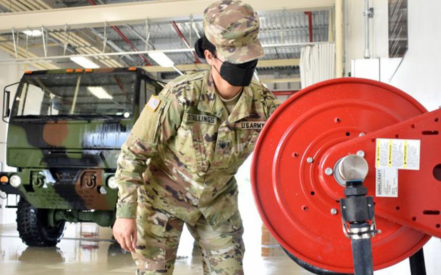 Spc. Brianna Stallings, assigned to the 38th Air Defense Artillery Brigade, rolls up a hose at the U.S. Army Garrison Japan Wash Rack at Sagami General Depot, Japan, Sept. 21. (Photo Credit: Winifred Brown)