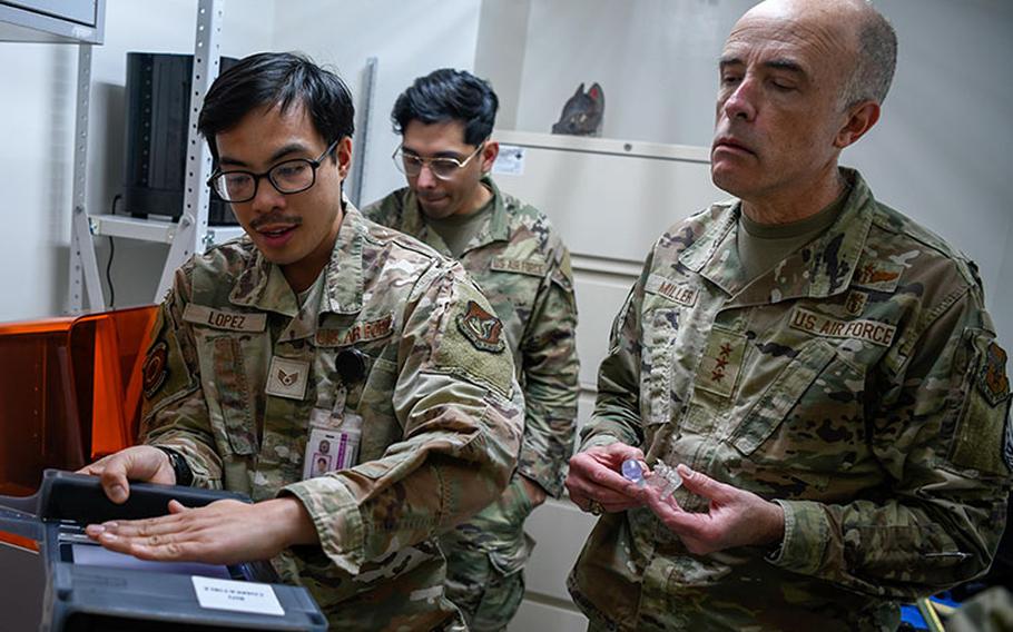 Staff Sgt. Voltaire Lopez, dental lab technician for the 374th Dental Squadron (left), shows Lt. Gen. Robert Miller, Surgeon General for the U.S. Air Force and Space Force (right), the dental technology at the 374th Medical Group at Yokota Air Base, Japan, Feb. 27, 2023. Following a tour of the facilities, Miller and his team recognized the Yokota MDG staff for their excellent work and dedication by giving them personal coins. (U.S. Air Force photo by Airman Jarrett Smith)