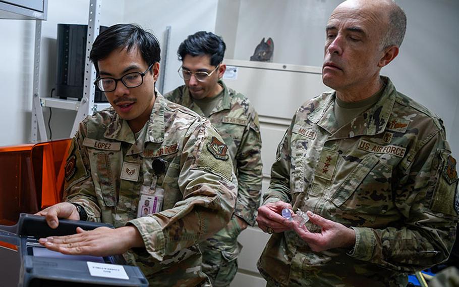 Staff Sgt. Voltaire Lopez, dental lab technician for the 374th Dental Squadron (left), shows Lt. Gen. Robert Miller, Surgeon General for the U.S. Air Force and Space Force (right), the dental technology at the 374th Medical Group at Yokota Air Base, Japan, Feb. 27, 2023. Following a tour of the facilities, Miller and his team recognized the Yokota MDG staff for their excellent work and dedication by giving them personal coins. (U.S. Air Force photo by Airman Jarrett Smith)