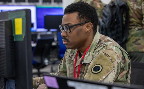 Photo Of Spc. Antonio French, an air defense battle management system operator, assigned to Headquarters and Headquarters Battalion, I Corps, checks on the status of the units during Yama Sakura 87.