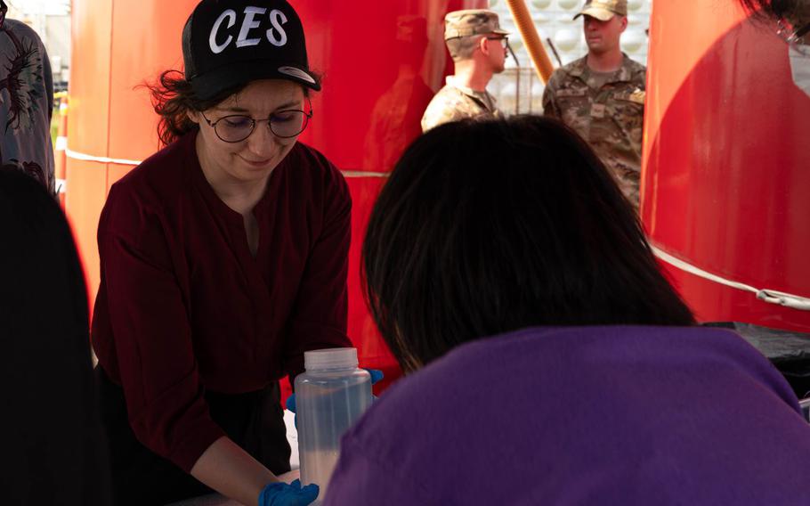Dr. Callie Oldfield, 374th Civil Engineer Squadron environmental scientist, holds filtered water from a water filtration system at Yokota Air Base, Japan.