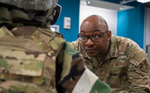 Photo Of U.S. Air Force Tech. Sgt. Jonathan Fleming, 374th Communications Squadron quality assurance evaluator, inspects mission-oriented protective posture gear during exercise Samurai Relay at Sagami General Depot, Japan.