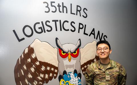 Photo Of Wild Weasel of the Week (WWoW), U.S. Air Force Senior Airman Davis Qian, 35th Logistics Readiness Squadron (LRS) base support agreement manager, poses in front of a mural at his work center at Misawa Air Base, Japan.