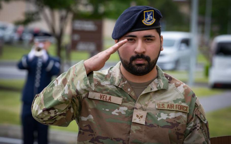 U.S. Air Force Senior Airman Kevin Vela, 374th Security Forces Squadron patrolman, renders a salute during the playing of taps, in remembrance of the fallen, at a retreat ceremony for the National Police Week.