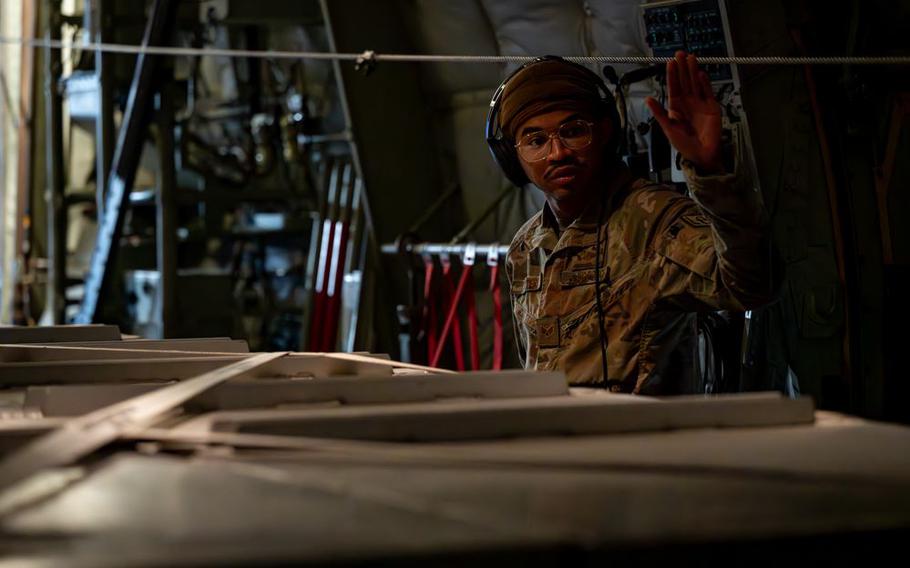 U.S. Air Force Senior Airman Milo Carter, 374th Operations Support Squadron instructor loadmaster, directs Airmen pushing cargo into a C-130 Hercules at Misawa Air Base, Japan, Jan. 14, 2025.