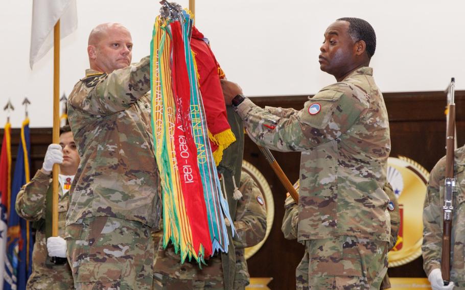 Lt. Col. Erik Hansen, left, commander of the 35th Combat Sustainment Support Battalion, and Command Sgt. Maj. Richard Williams Jr., senior enlisted leader for the battalion, uncase the colors for the 765th Transportation (Terminal) Battalion...