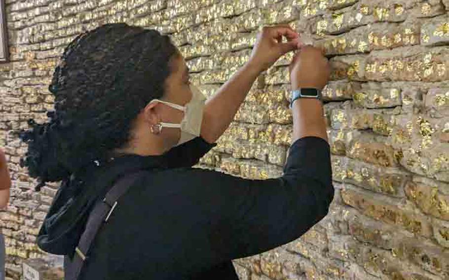 author applying gold leaf to the wall for good luck