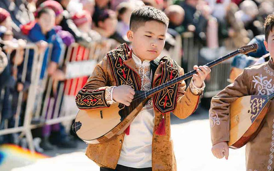 Playing Mongolian string instrument in Nauryz parade