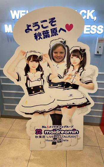 posing for a photo with a maid panel