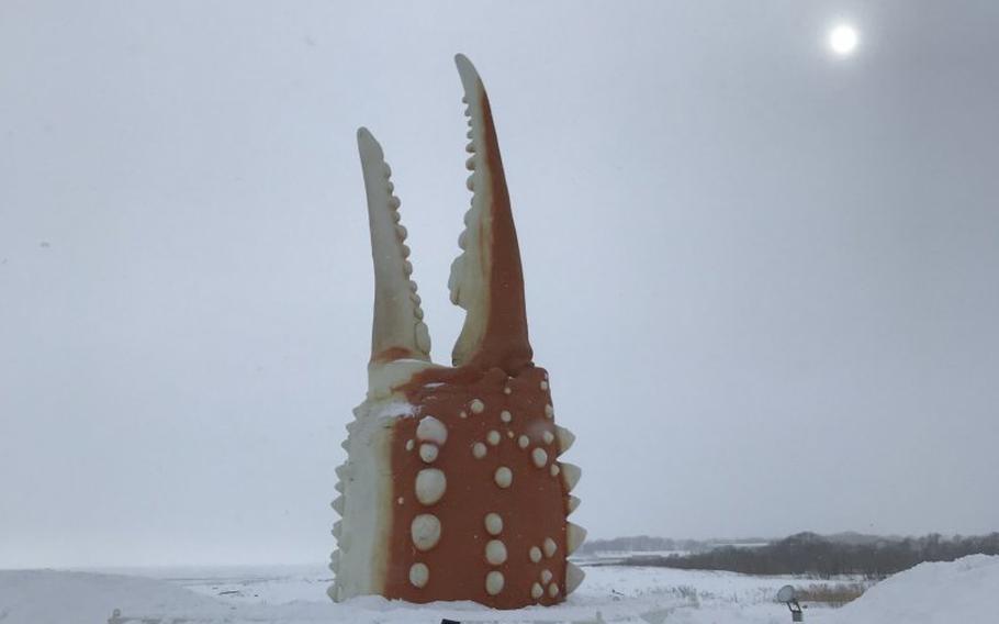 Braving the cold winter air and snow to check out the iconic crab claw. Photo by Kim B.