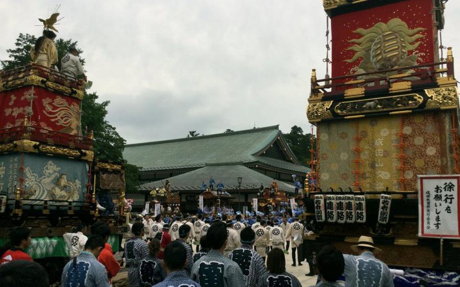 The opening ceremony with elaborate floats and participants in colorful clothing.