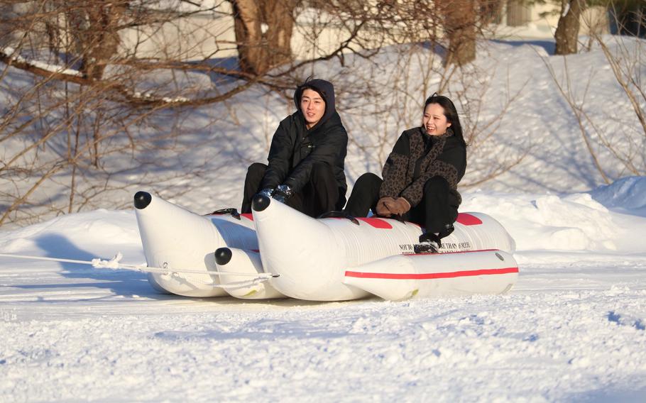 a couple enjoys sledding