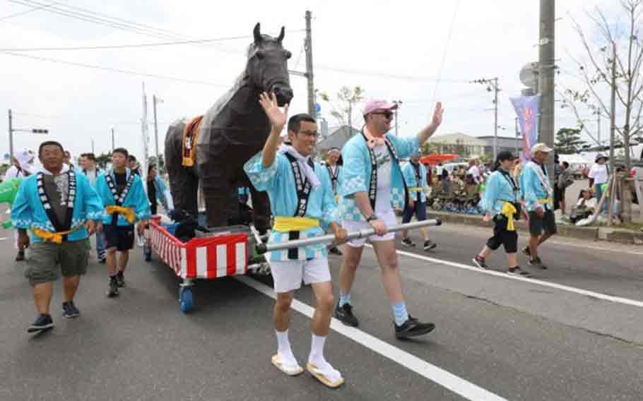 Capt. Henry Etchberger, right, commander of the 10th Missile Defense Battery at the Shariki Communication Site, pulls a horse-shaped float with Soldiers from his unit and members of the Japan Air Self-Defense during the annual Umaichi Matsuri.