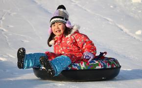 a child enjoys sledding