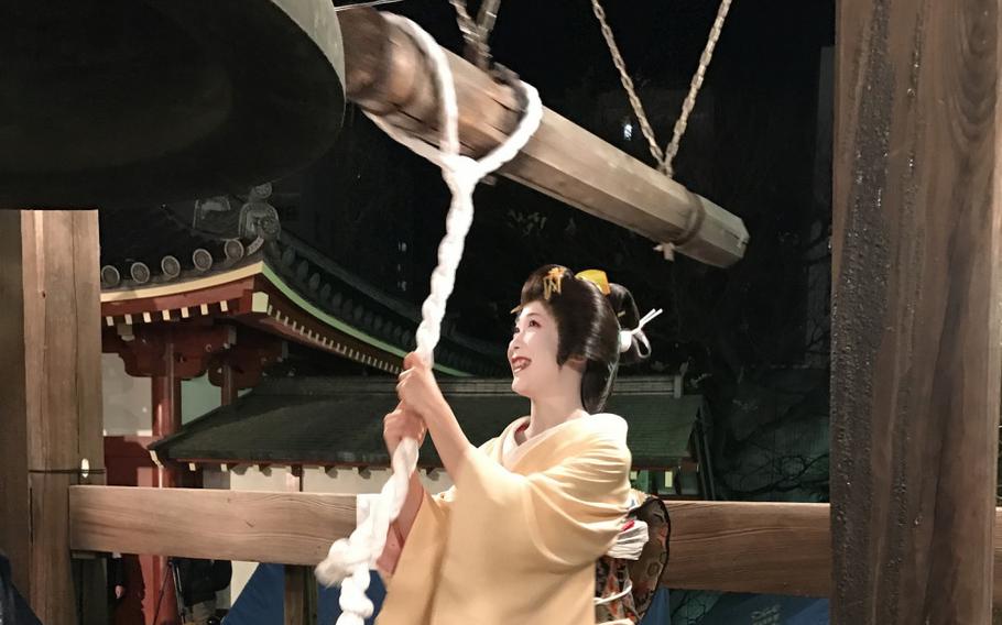 a woman ringing the bell at Senso-ji Temple for new year