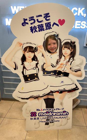 posing for a photo with a maid panel